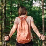 Female hiker with hiking poles resting in forest